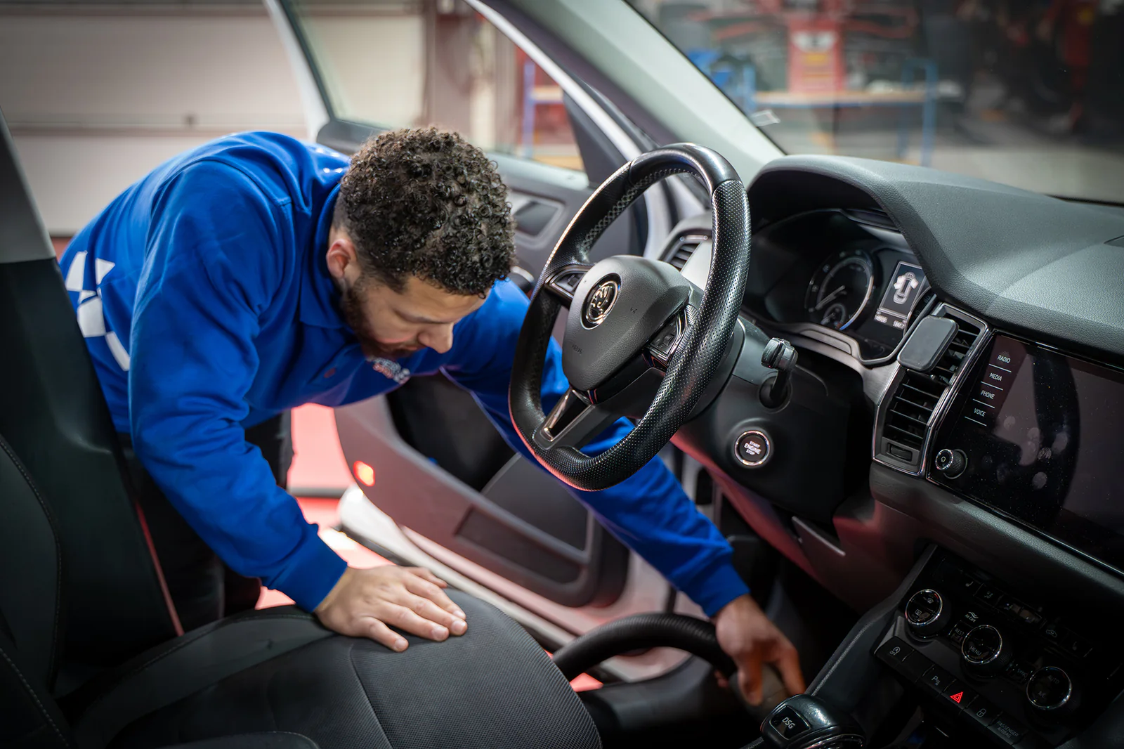 Medewerker reinigt een portier bij de interieurbehandeling – SchippersStop Carwash Veldhoven, Veldhoven