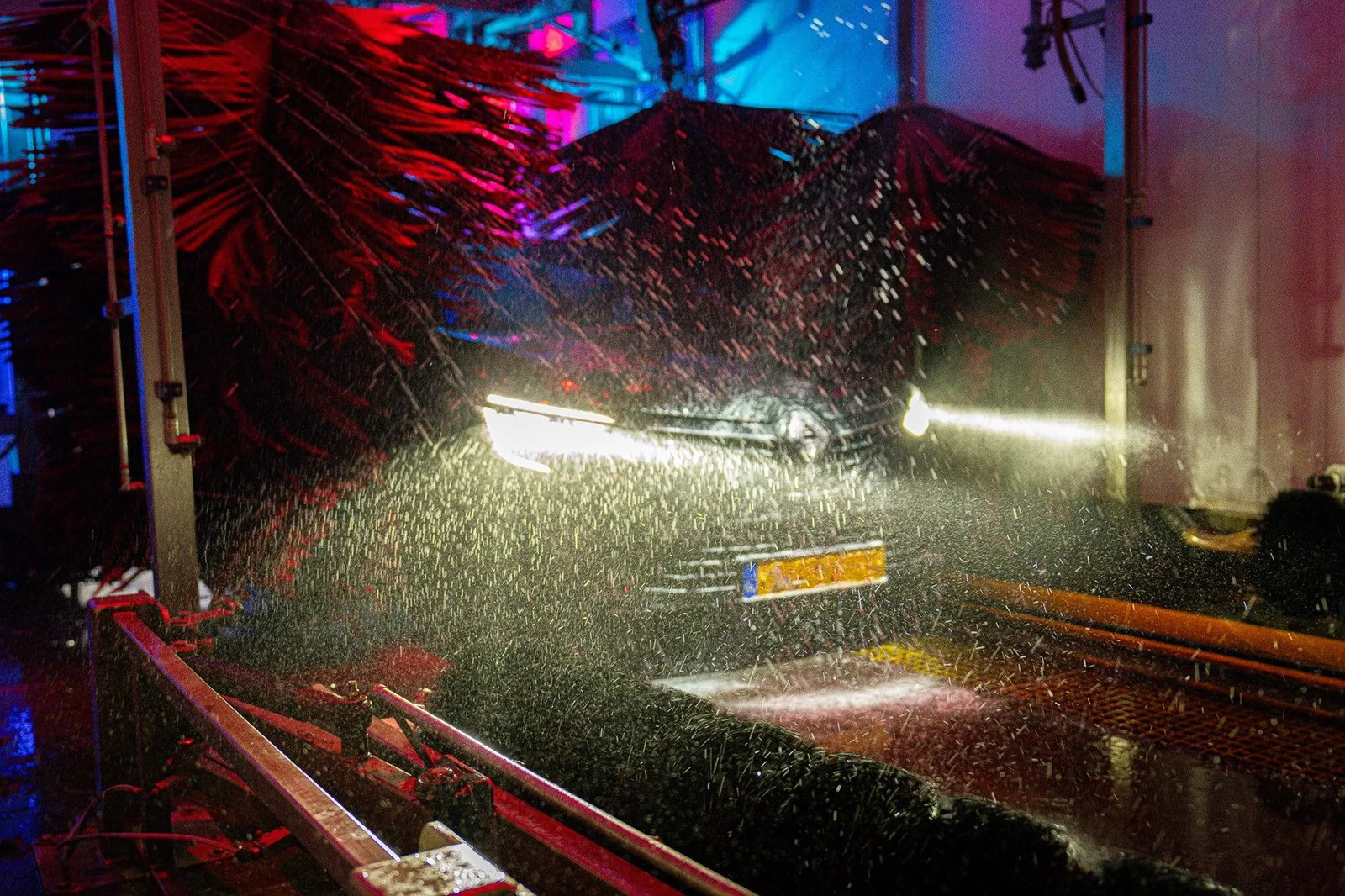 Auto tussen rode borstels in de wasstraat – Excellent Carwash Amsterdam, Amsterdam