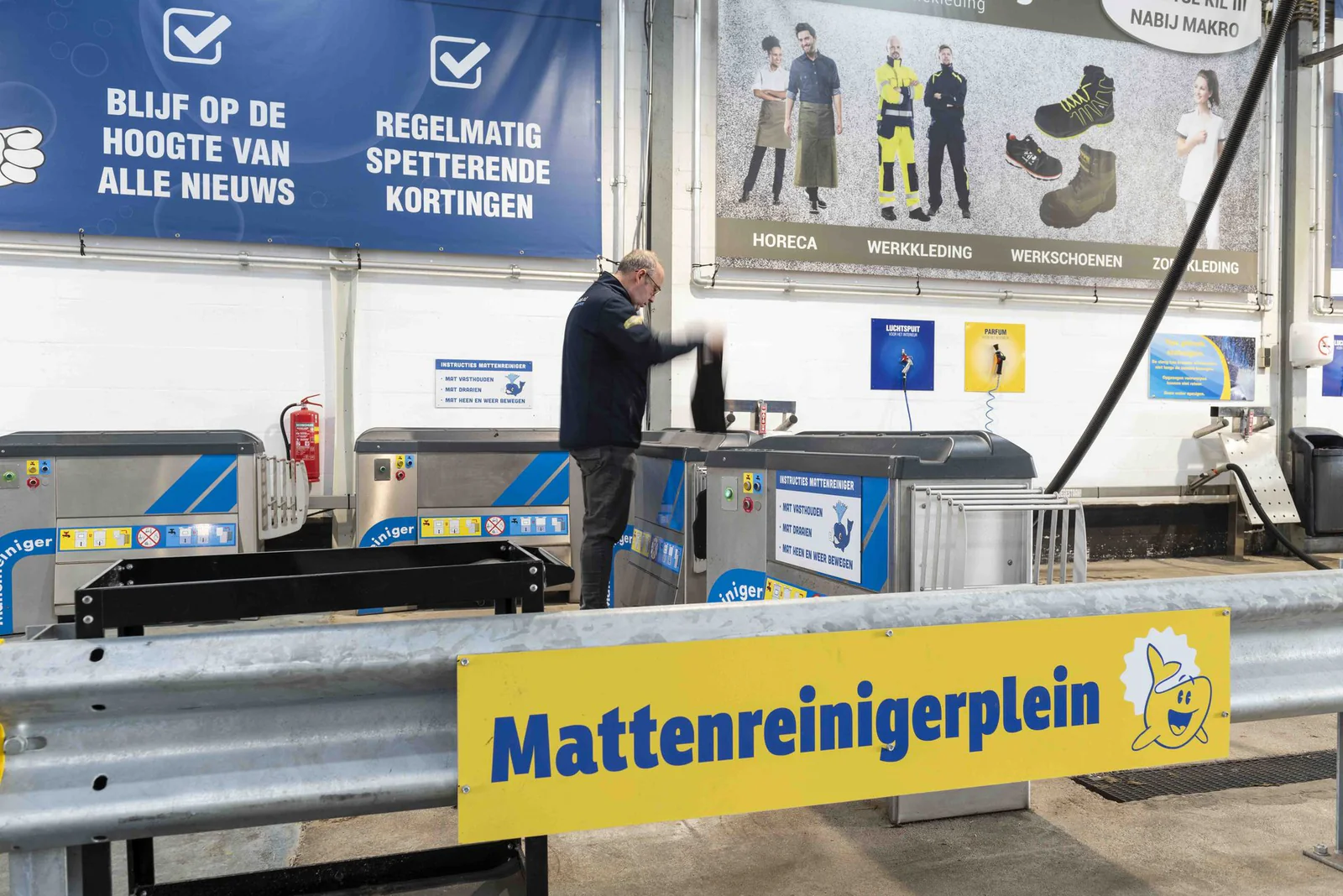 Man houdt een automat in een mattenreiniger op een overdekt mattenreinigerplein